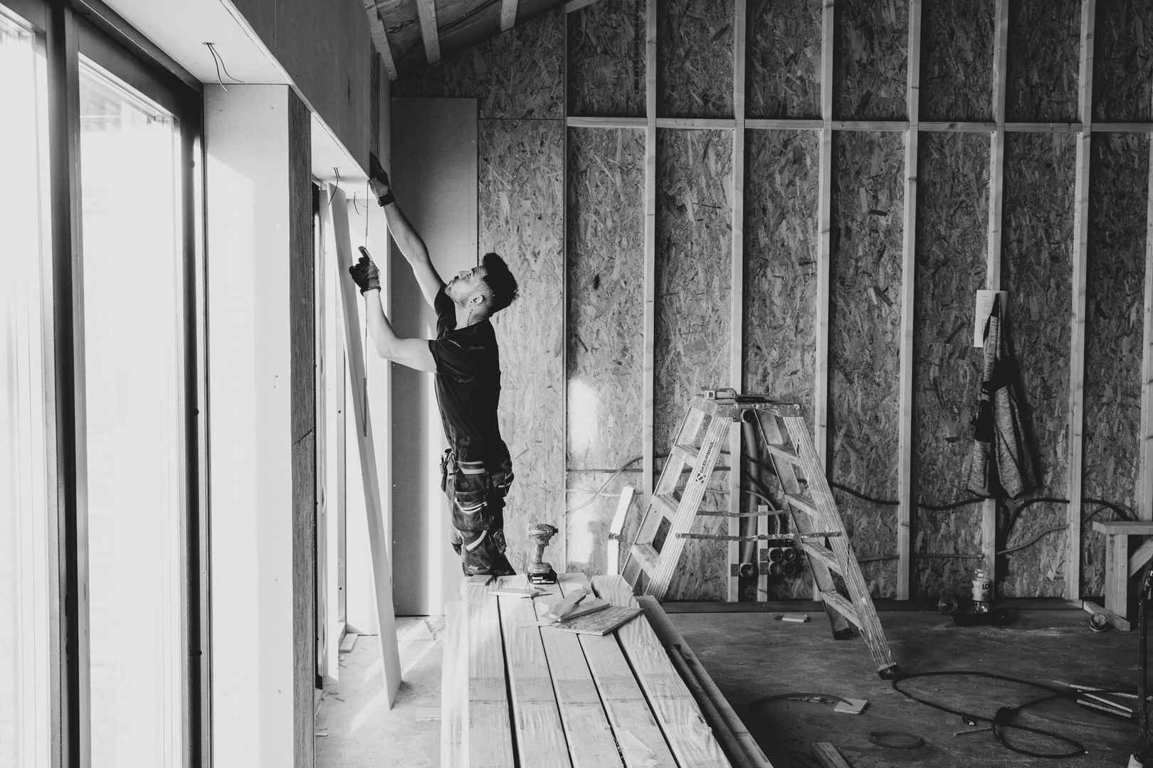 Hantverkare monterar gipsskiva i ett rum under renovering